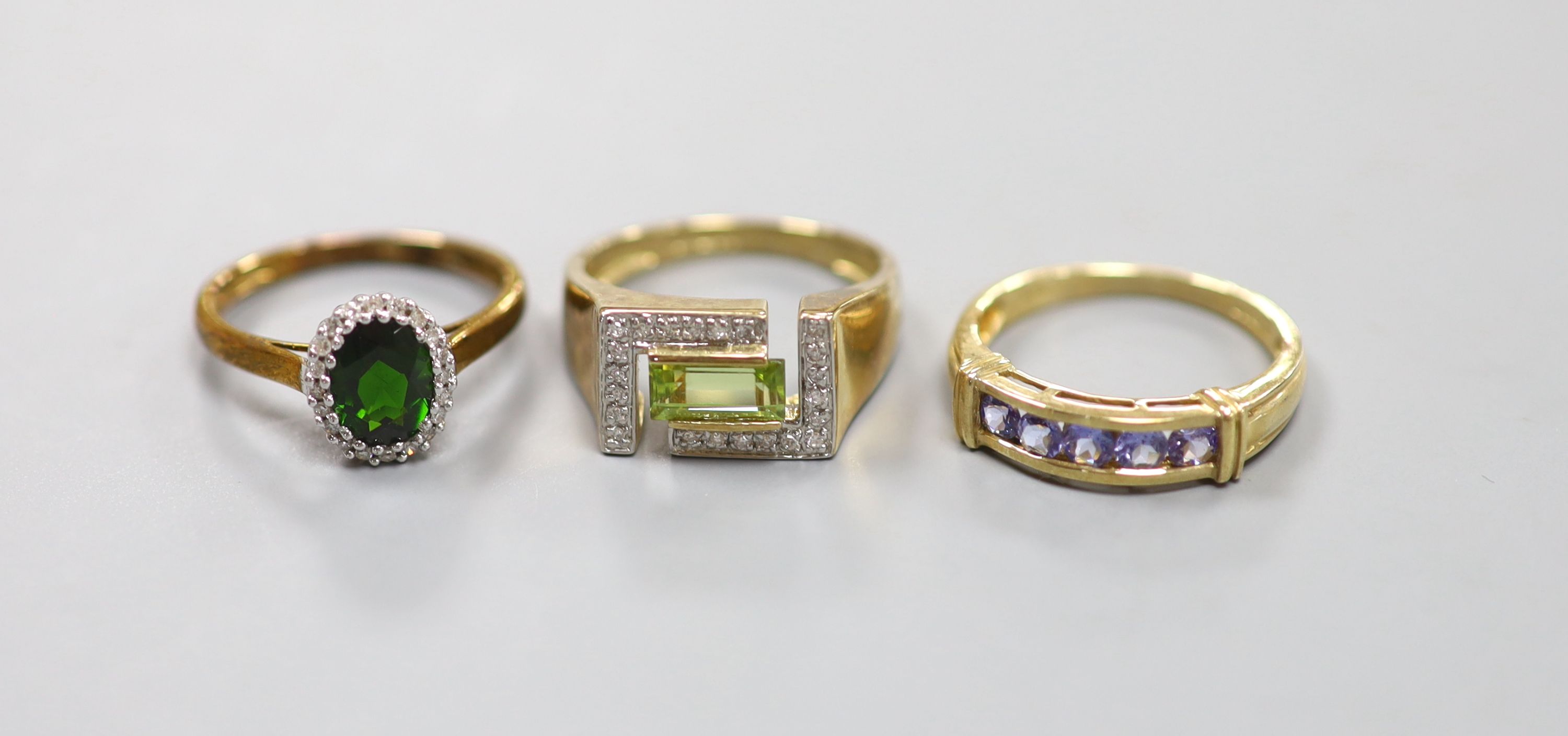 A peridot and diamond set 9ct gold ring, a 9ct gold cluster ring and a 9ct gold line-set five-stone ring
